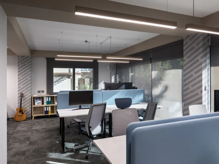 The open-plan floor, desks facing the windows