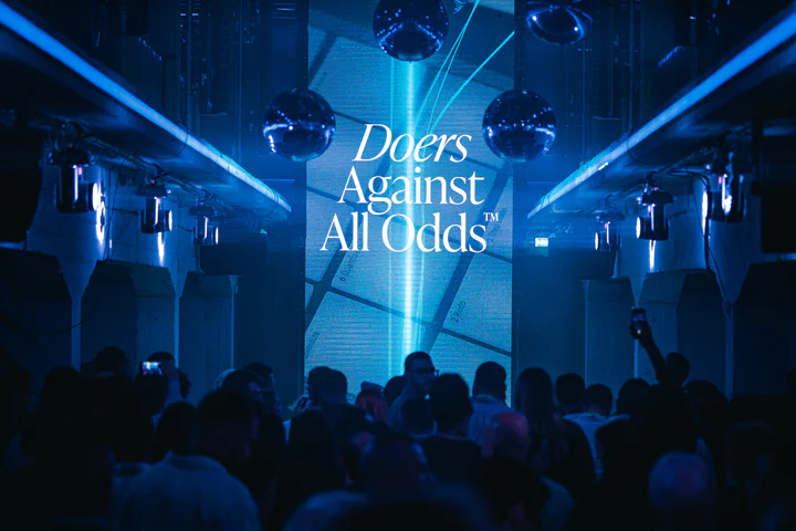 A Doers Summit party under mirror balls and blue beams
