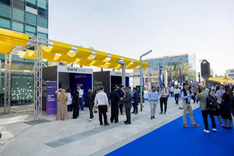 Founders and investors in conversation along the expo boulevard at a Doers event