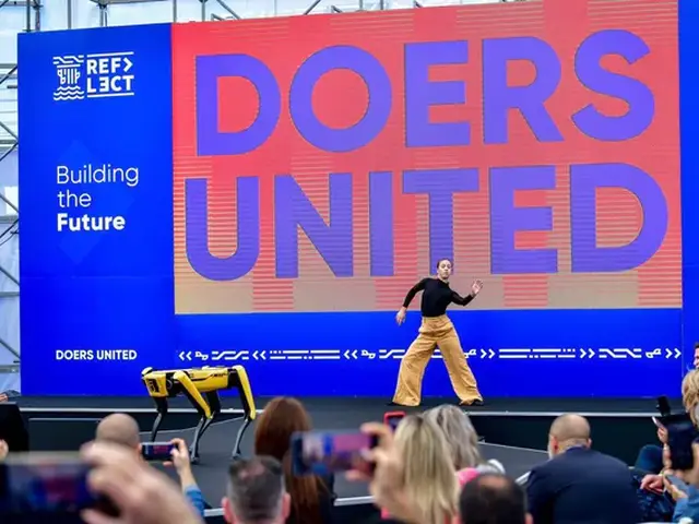 The Doers United main stage with a performer and a robot dog