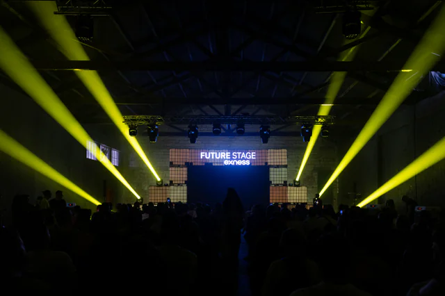 Yellow beams fanning over a crowd facing the Future Stage