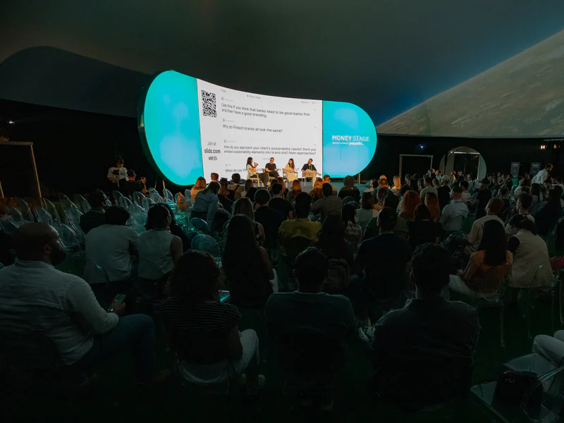 A panel on the dome stage, its title card projected across the curved ceiling