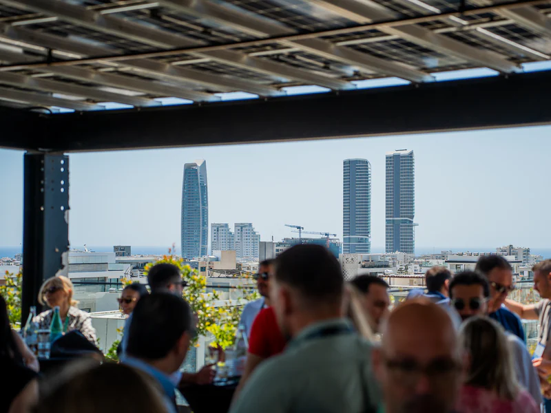 A rooftop gathering with the city towers behind